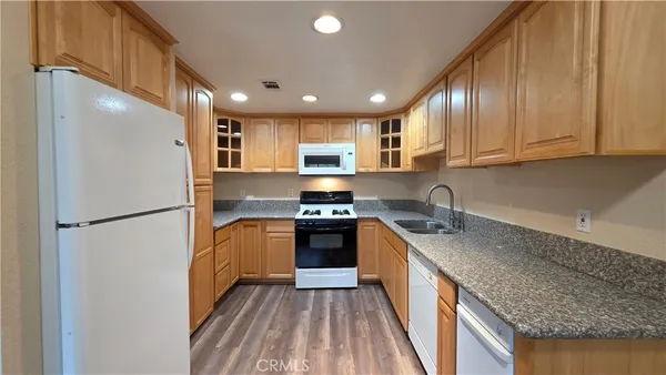 a kitchen with granite countertop stainless steel appliances a refrigerator a sink and a stove