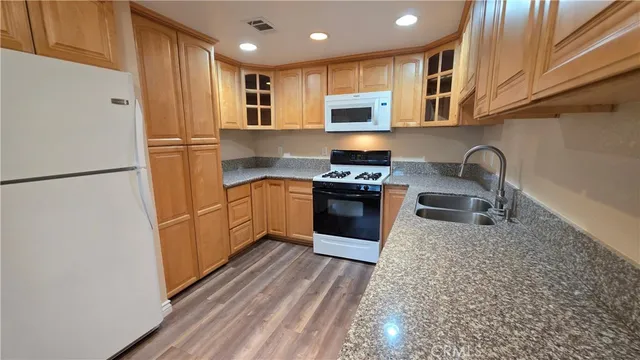 a kitchen with stainless steel appliances granite countertop a refrigerator a stove a sink and a microwave