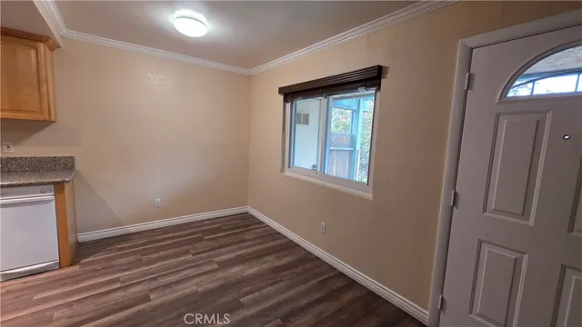 a view of empty room with window and wooden floor