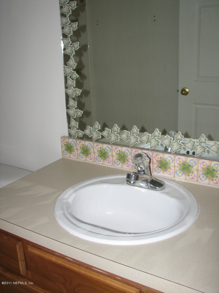 7920 Merrill Road, Unit 2108 Jacksonville, FL 32277 - Photo 5 of 15 a bathroom with a granite countertop sink and a mirror