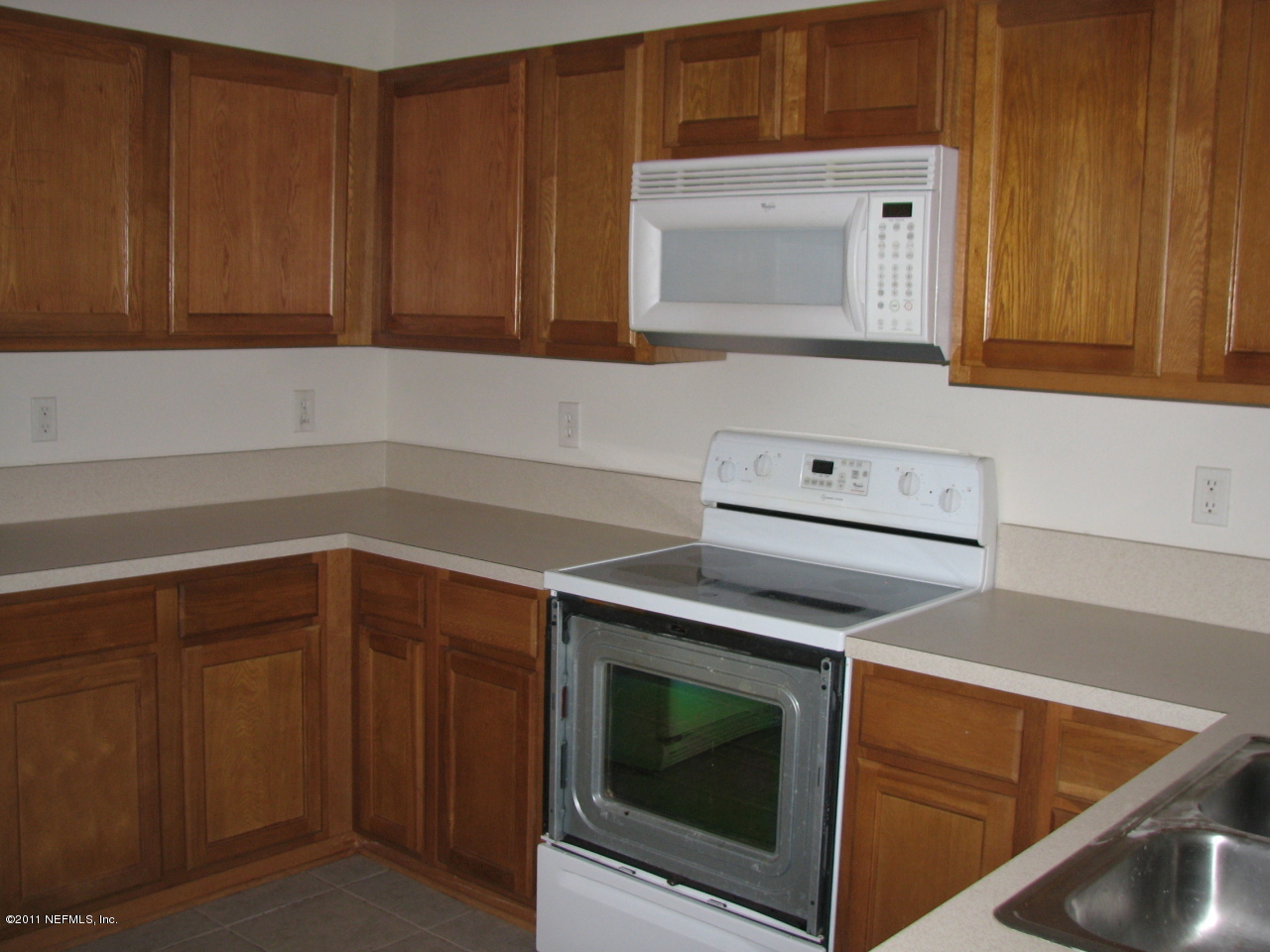 7920 Merrill Road, Unit 2108 Jacksonville, FL 32277 - Photo 8 of 15 a kitchen with wooden cabinets and a stove top oven