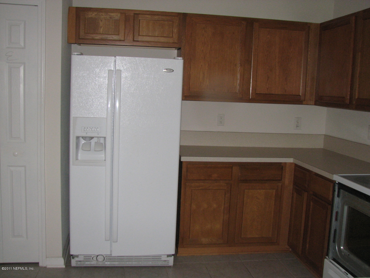 7920 Merrill Road, Unit 2108 Jacksonville, FL 32277 - Photo 9 of 15 a kitchen with a white cabinets and a refrigerator