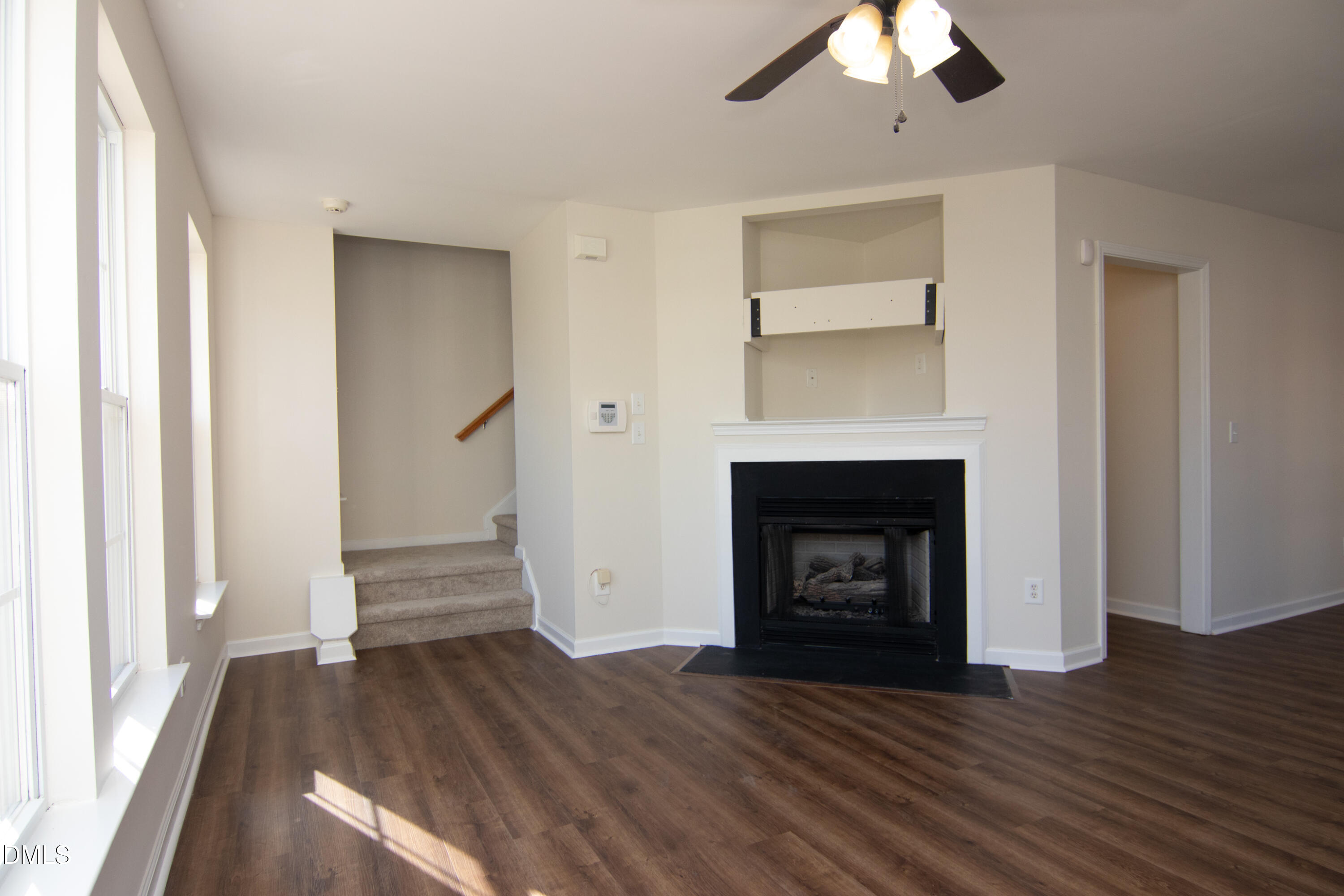 9903 Grettle Court Raleigh, NC 27617 - Photo 11 of 40 a view of an empty room with wooden floor fireplace and a window