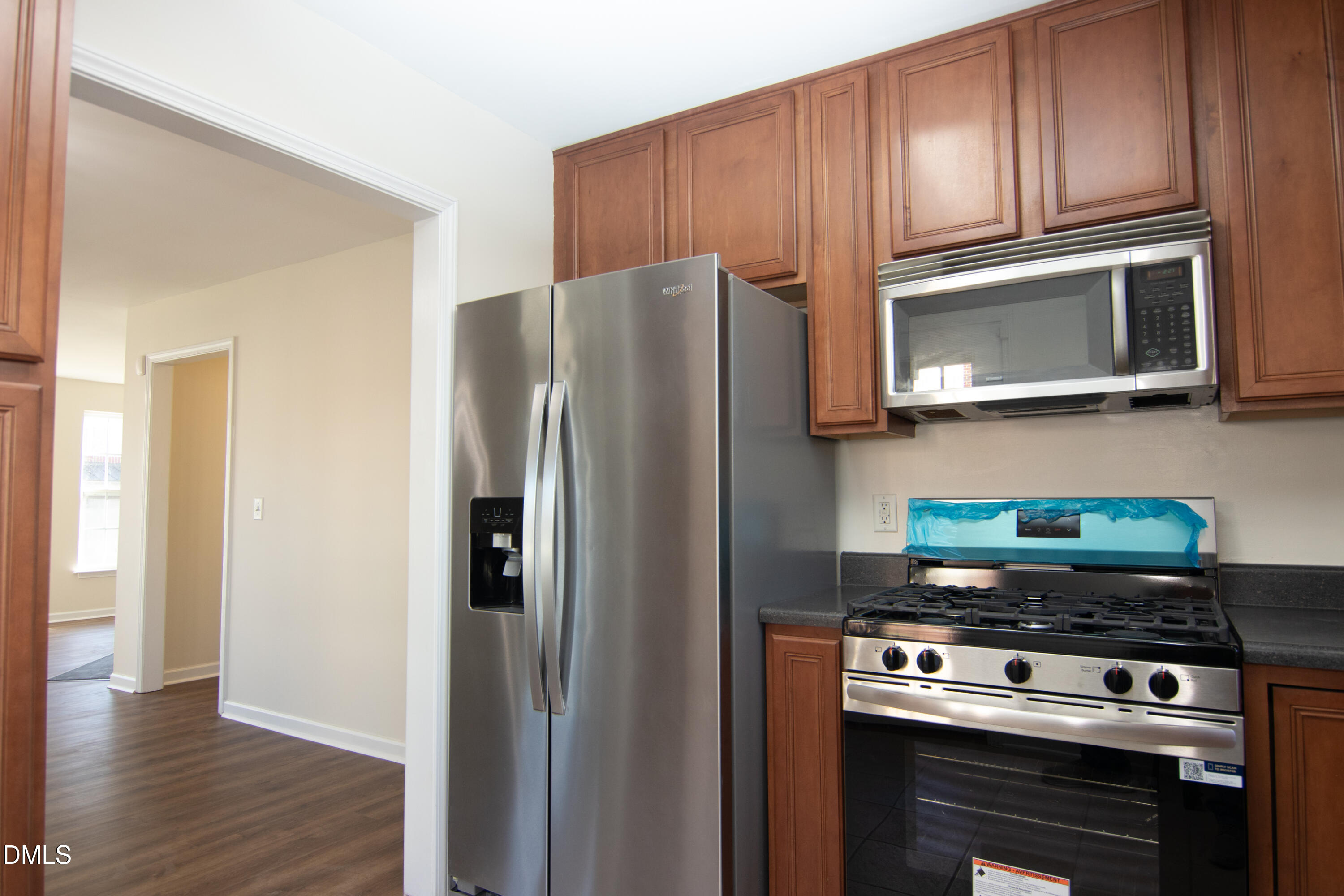 9903 Grettle Court Raleigh, NC 27617 - Photo 3 of 40 a kitchen with stainless steel appliances wooden cabinets and a stove top oven