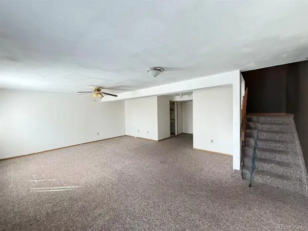 a view of an empty room with a ceiling fan