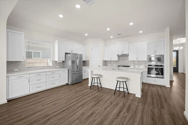 a kitchen with white cabinets stainless steel appliances and center island