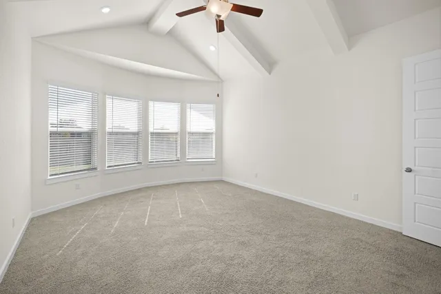 an empty room with windows and chandelier fan