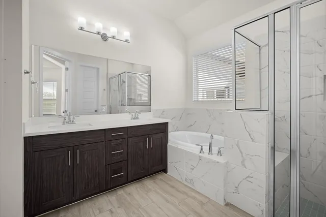a spacious bathroom with a double vanity sink a large mirror and a bathtub