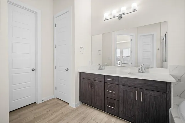 a bathroom with double sink and a mirror