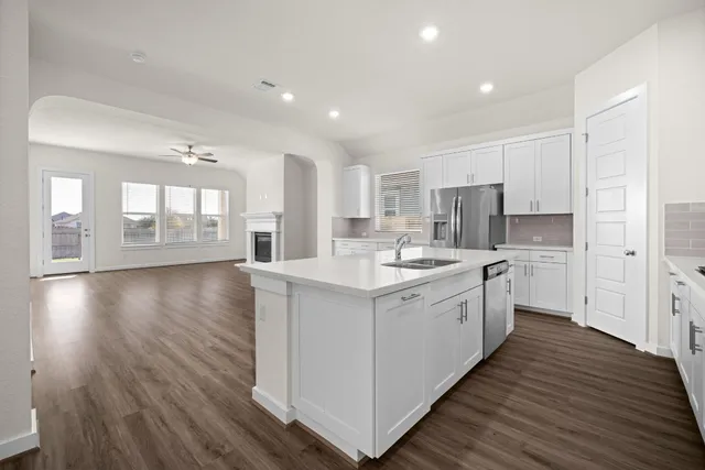 a kitchen with wooden floors and white walls