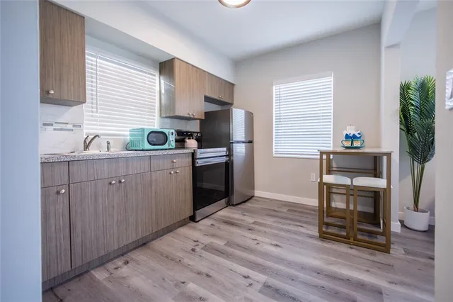 a kitchen with a sink cabinets stainless steel appliances and a window