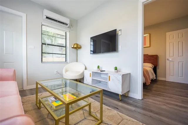 a living room with furniture a flat screen tv and a window