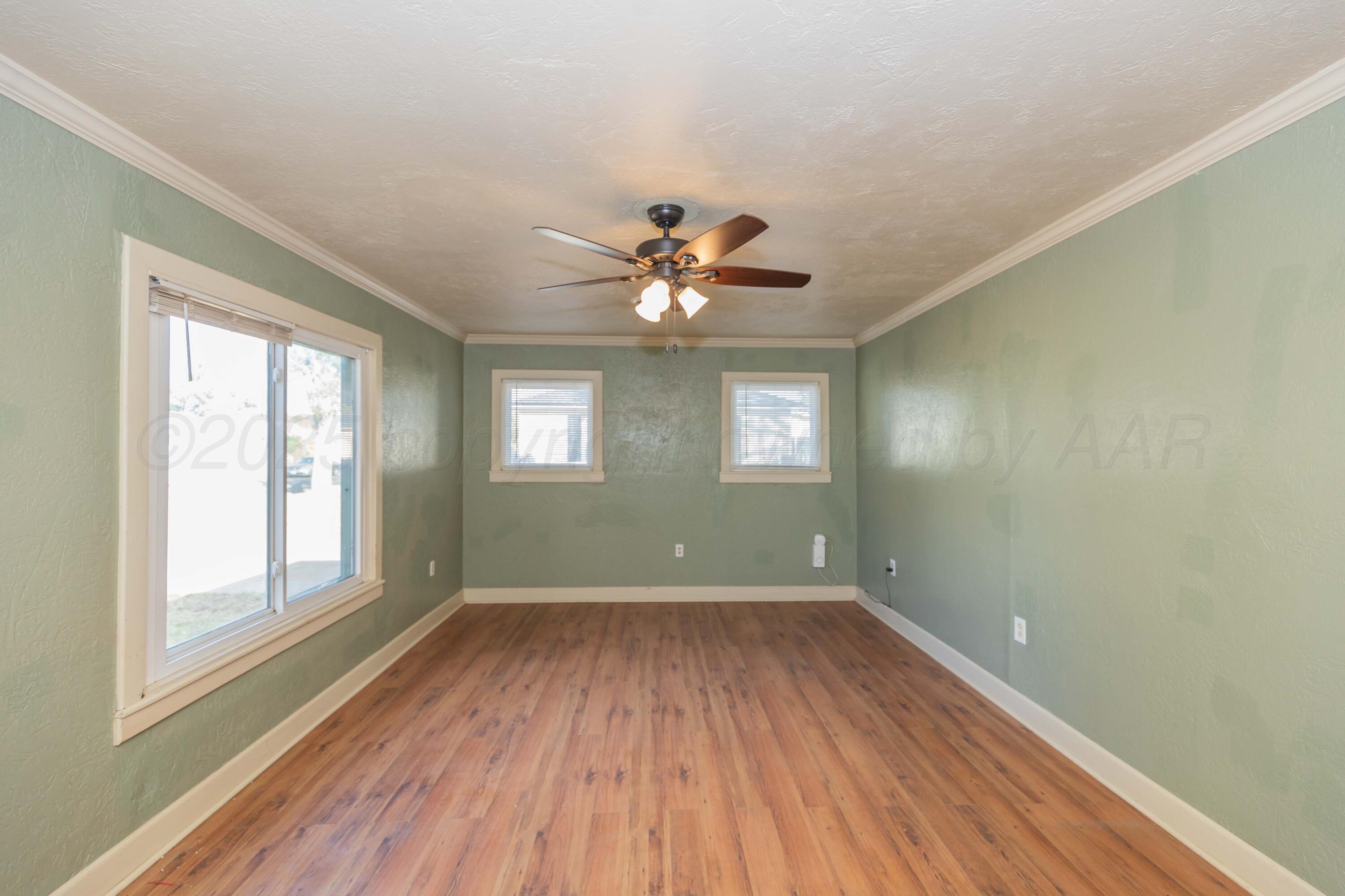 4209 South Lipscomb Street Amarillo, TX 79110 - Photo 4 of 31 a view of an empty room with a window and wooden floor
