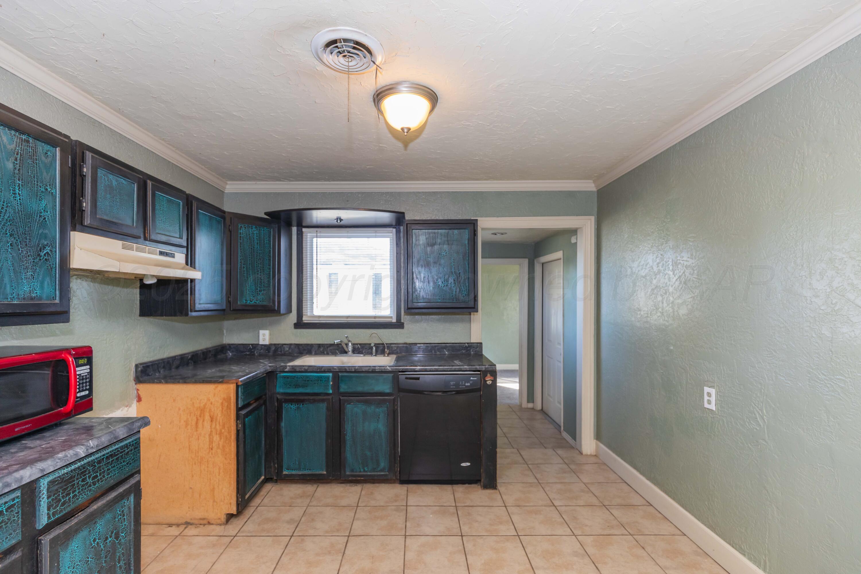 4209 South Lipscomb Street Amarillo, TX 79110 - Photo 8 of 31 a kitchen with a sink window and cabinets