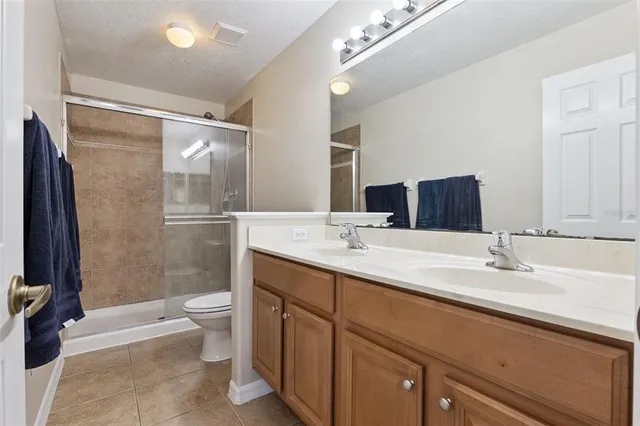 a bathroom with a double vanity sink toilet mirror and shower