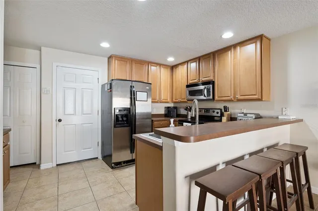a kitchen with kitchen island a refrigerator and a stove top oven
