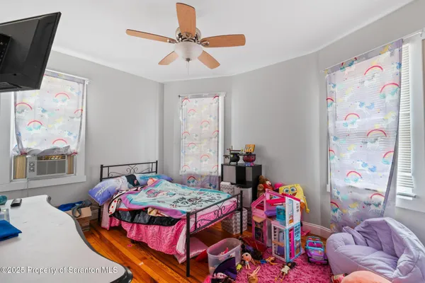 a bedroom with a bed a flat screen tv and window