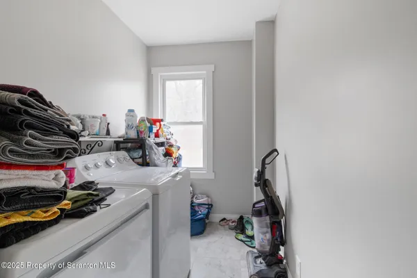a bathroom with a granite countertop sink a toilet a mirror and a window