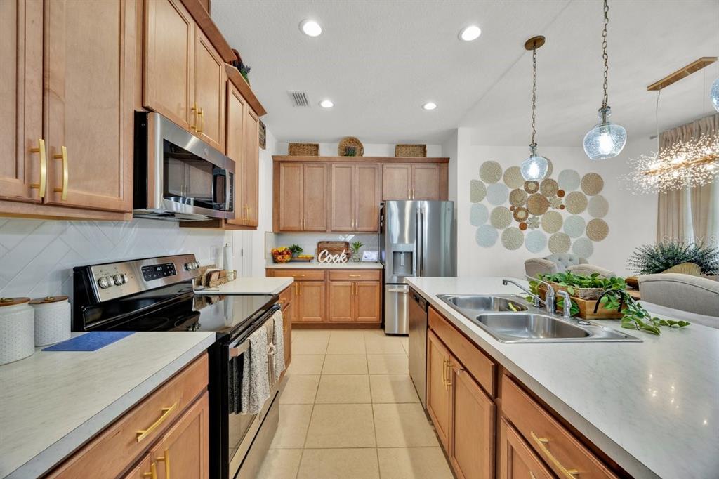 5237 Royal Point Avenue Kissimmee, FL 34746 - Photo 8 of 28 a kitchen with stainless steel appliances granite countertop a sink a stove and a refrigerator