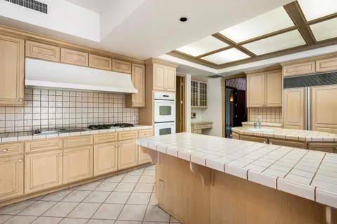 a bathroom with a granite countertop sink and a large mirror