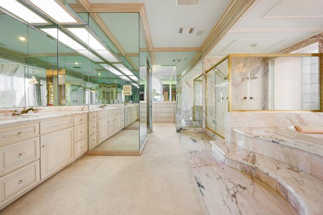 a bathroom with a granite countertop sink a toilet a mirror and shower