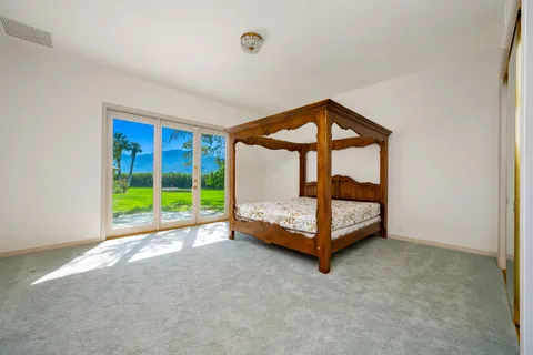 a living room with furniture a large window and gym equipment