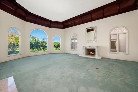 a view of an empty room with a fireplace and a window