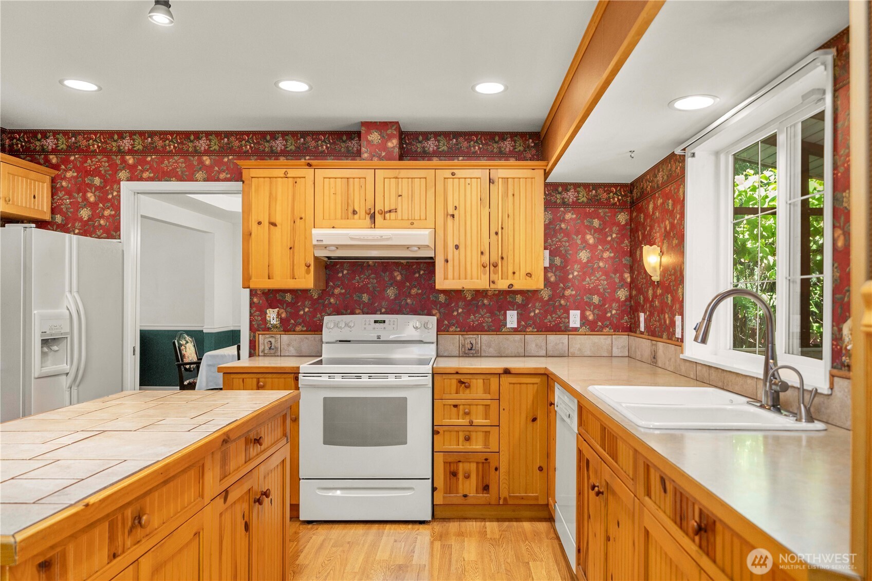 2469 South 224th Street Des Moines, WA 98198 - Photo 10 of 40 a kitchen with a stove a sink and a refrigerator