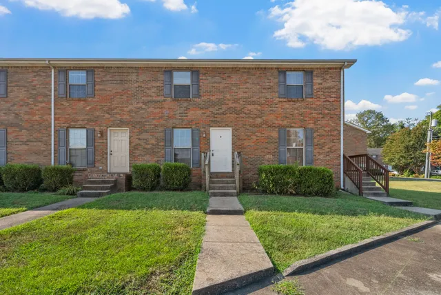 a front view of brick house with a yard