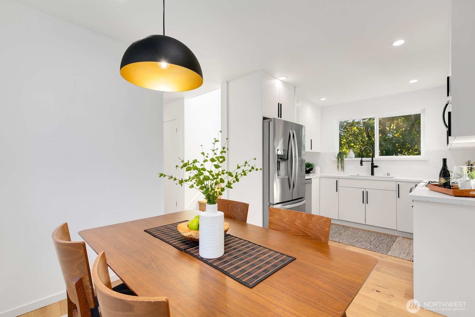 4531 26th Avenue Southwest Seattle, WA 98106 - Photo 11 of 22 a kitchen with stainless steel appliances kitchen island granite countertop a table chairs and a refrigerator