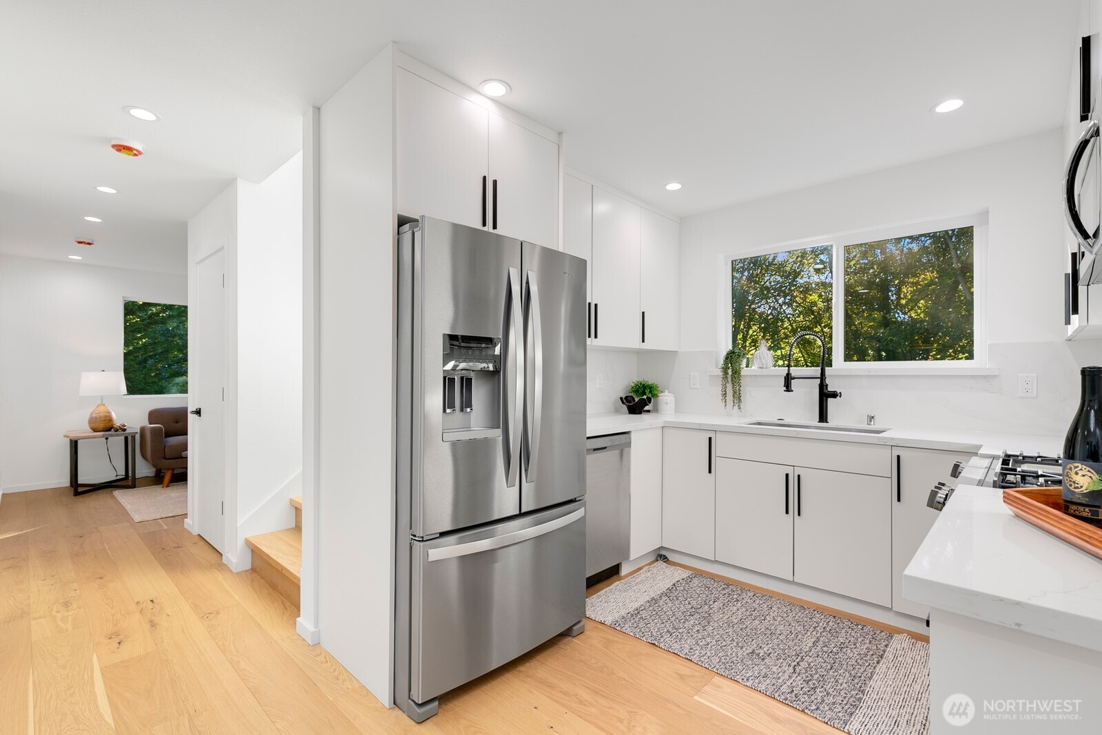 4531 26th Avenue Southwest Seattle, WA 98106 - Photo 8 of 22 a kitchen with white cabinets and stainless steel appliances