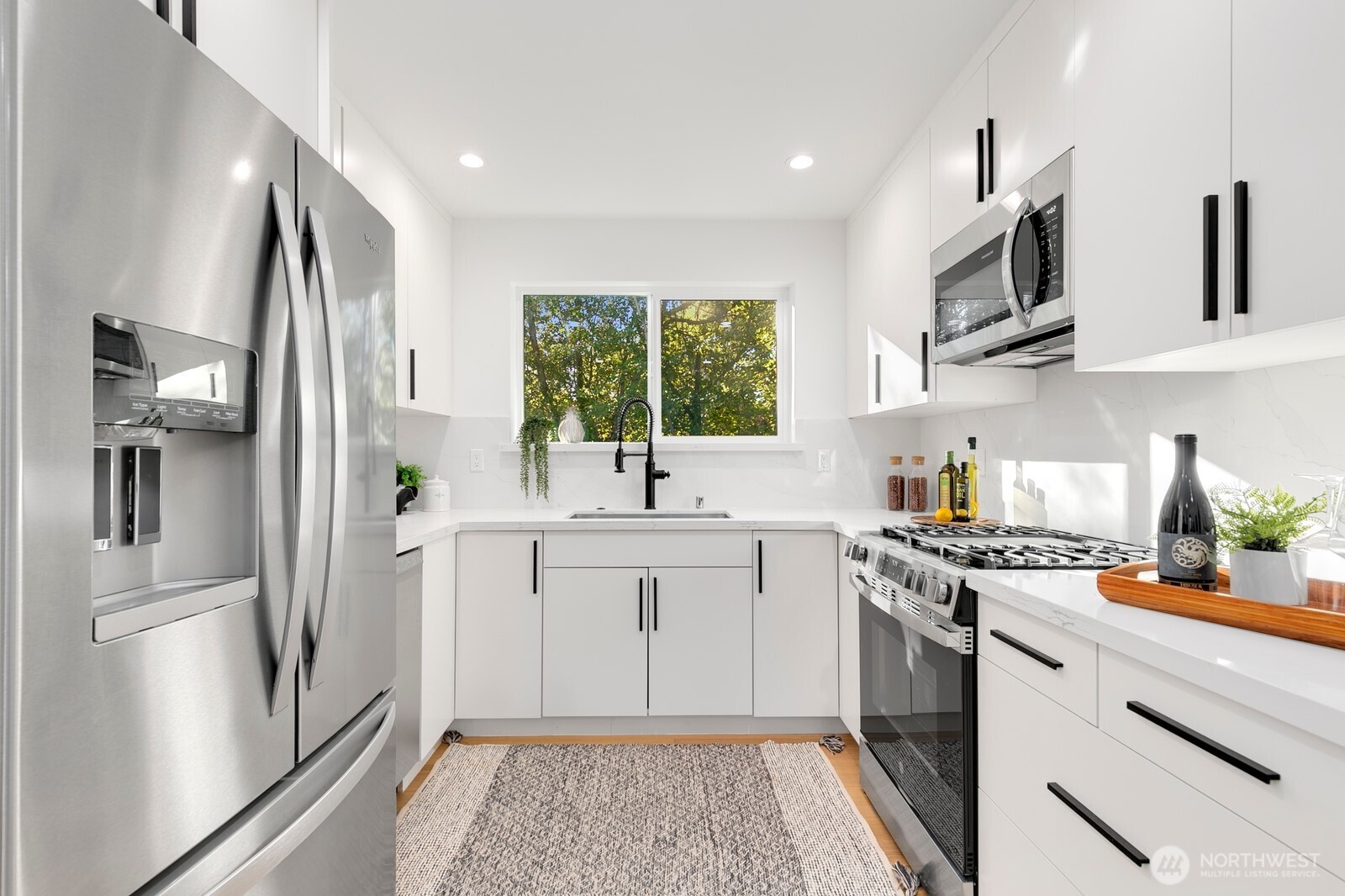 4531 26th Avenue Southwest Seattle, WA 98106 - Photo 10 of 22 a kitchen with stainless steel appliances a refrigerator sink and stove