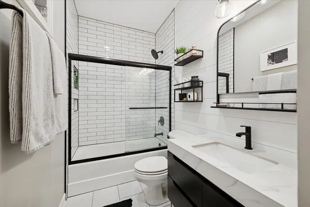 a bathroom with a sink a toilet and shower