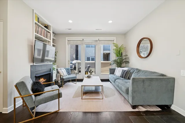 a living room with fireplace furniture and a large window