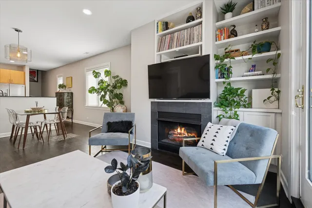 a living room with furniture a bookshelf and a flat screen tv