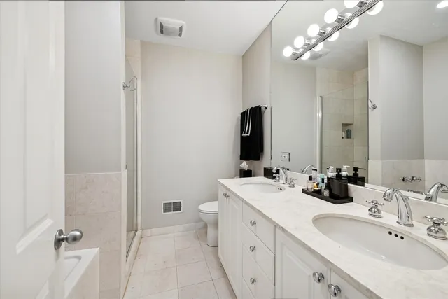a bathroom with a double vanity sink a mirror and a shower