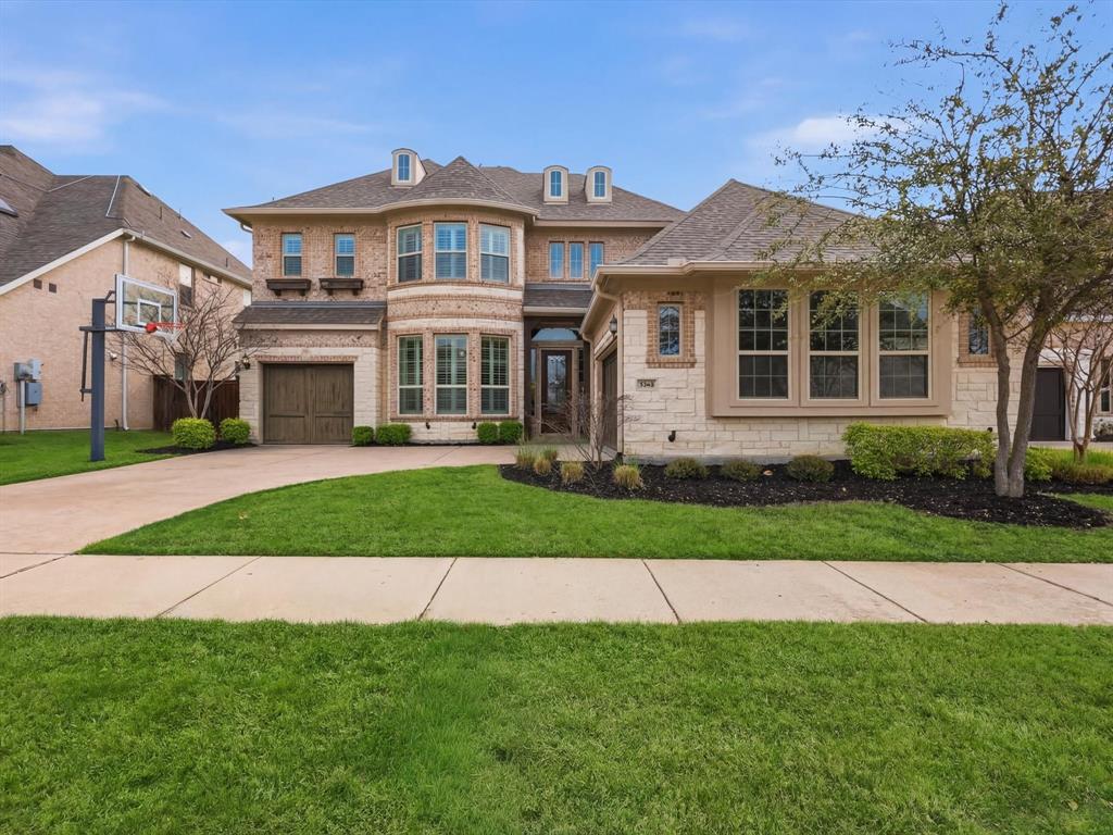 7050 Hay Seed Road Frisco, TX 75036 - Photo 1 of 1 View of front of home featuring driveway, a front yard, brick siding, a garage, and stone siding *Virtual Grass Enhancement Added*