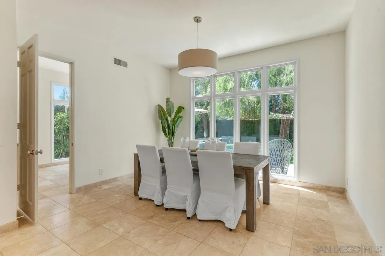 9678 Claiborne Square La Jolla, CA 92037 - Photo 11 of 38 a dining room with furniture a chandelier and a rug
