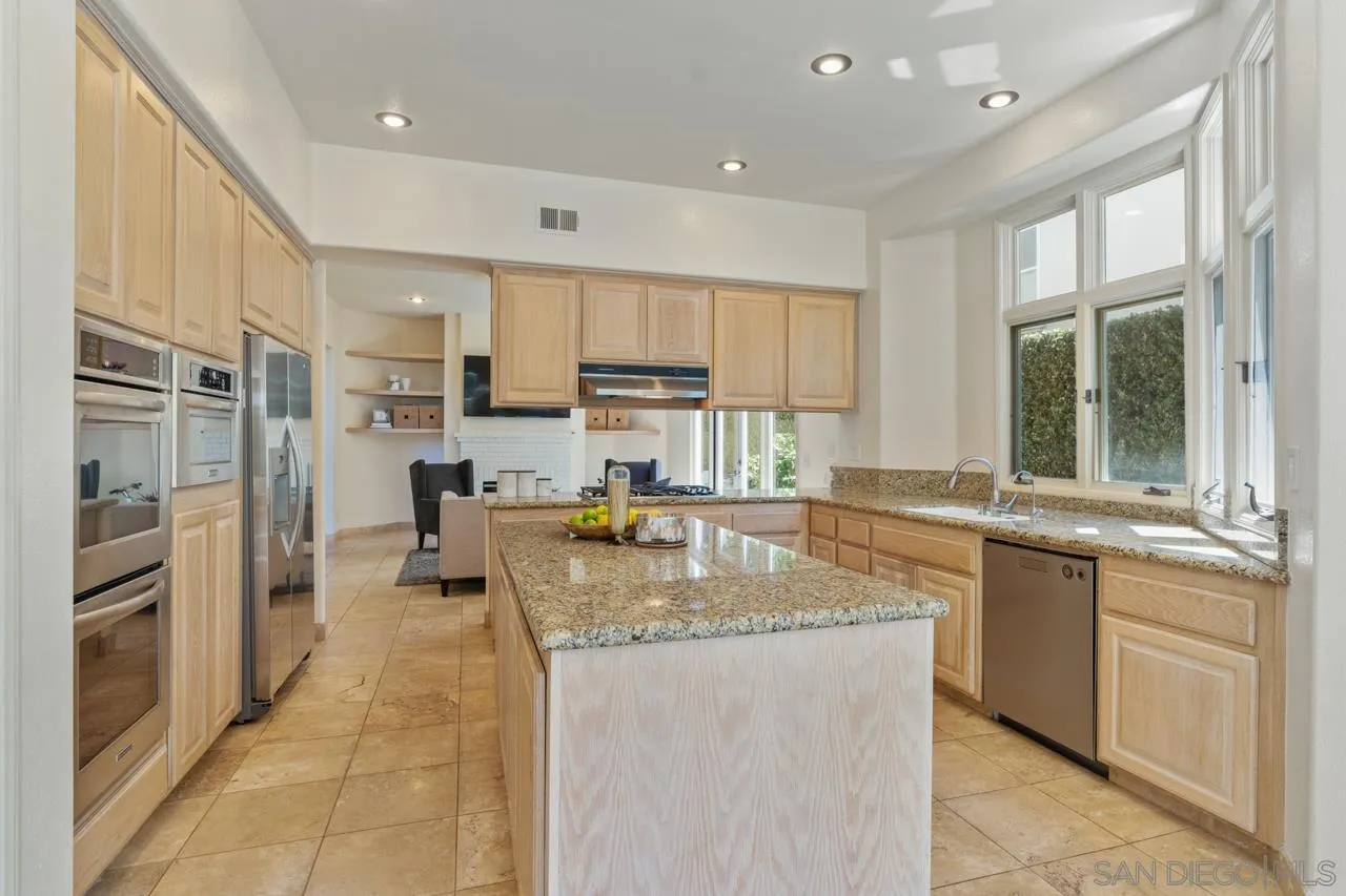 9678 Claiborne Square La Jolla, CA 92037 - Photo 13 of 38 a large kitchen with kitchen island granite countertop a large window and a sink