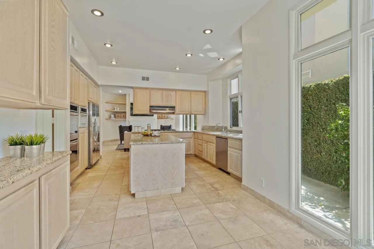 9678 Claiborne Square La Jolla, CA 92037 - Photo 15 of 38 a kitchen with stainless steel appliances granite countertop a refrigerator and a sink