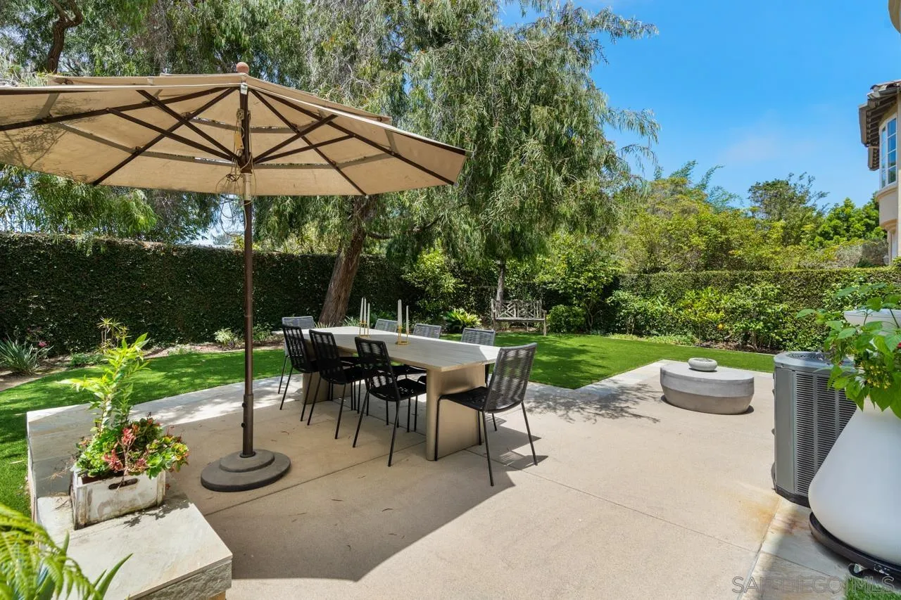9678 Claiborne Square La Jolla, CA 92037 - Photo 2 of 38 a view of a patio with couches table and chairs under an umbrella