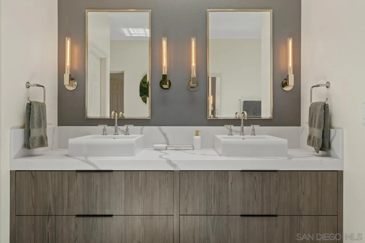 9678 Claiborne Square La Jolla, CA 92037 - Photo 23 of 38 a bathroom with a double vanity sink and a mirror