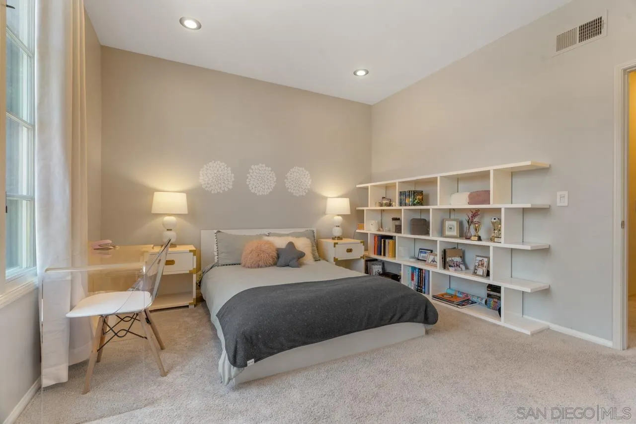 9678 Claiborne Square La Jolla, CA 92037 - Photo 29 of 38 a bedroom with a bed a table and a large closet with wooden floor