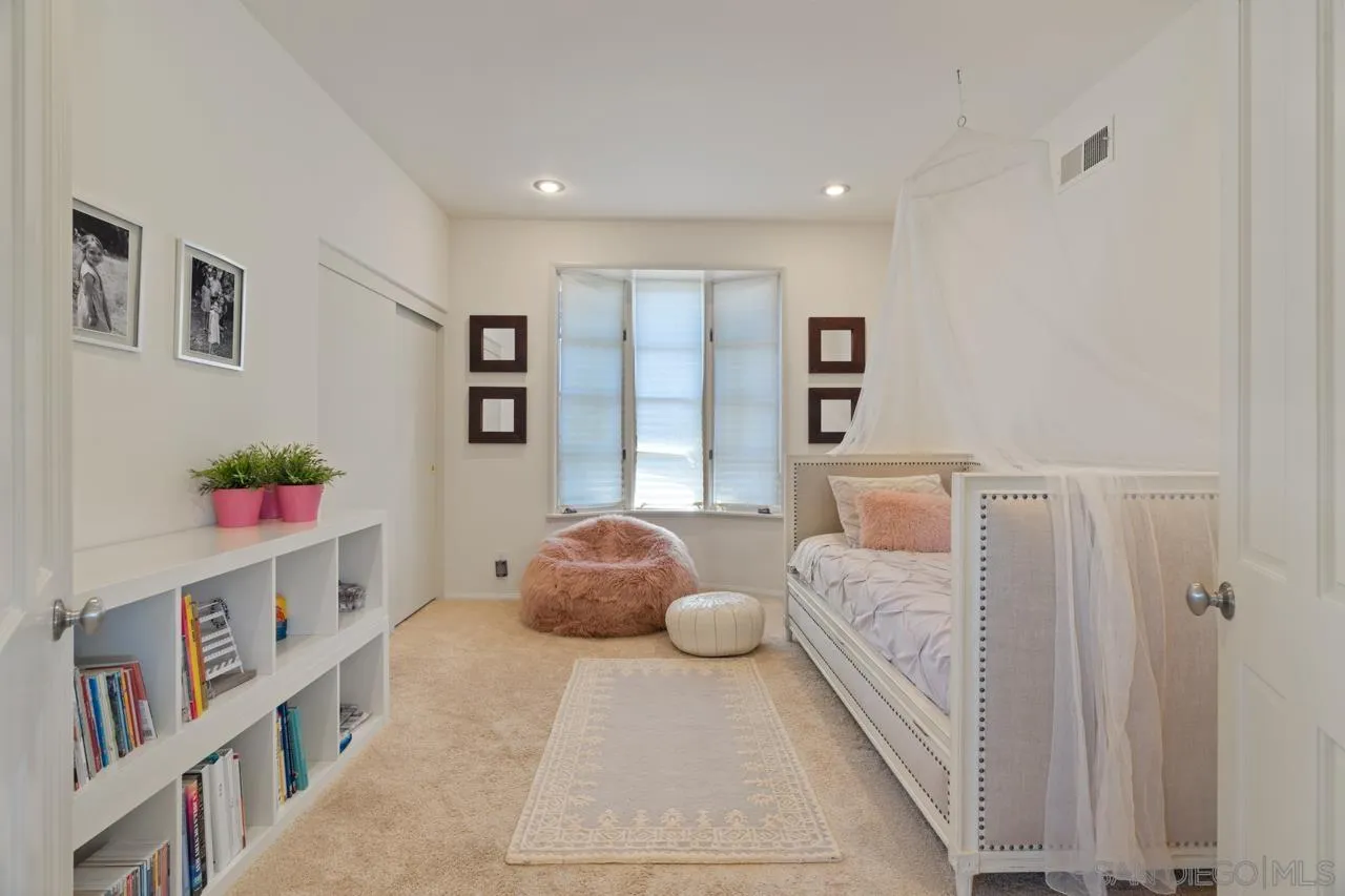 9678 Claiborne Square La Jolla, CA 92037 - Photo 31 of 38 a bedroom with furniture and a baby crib