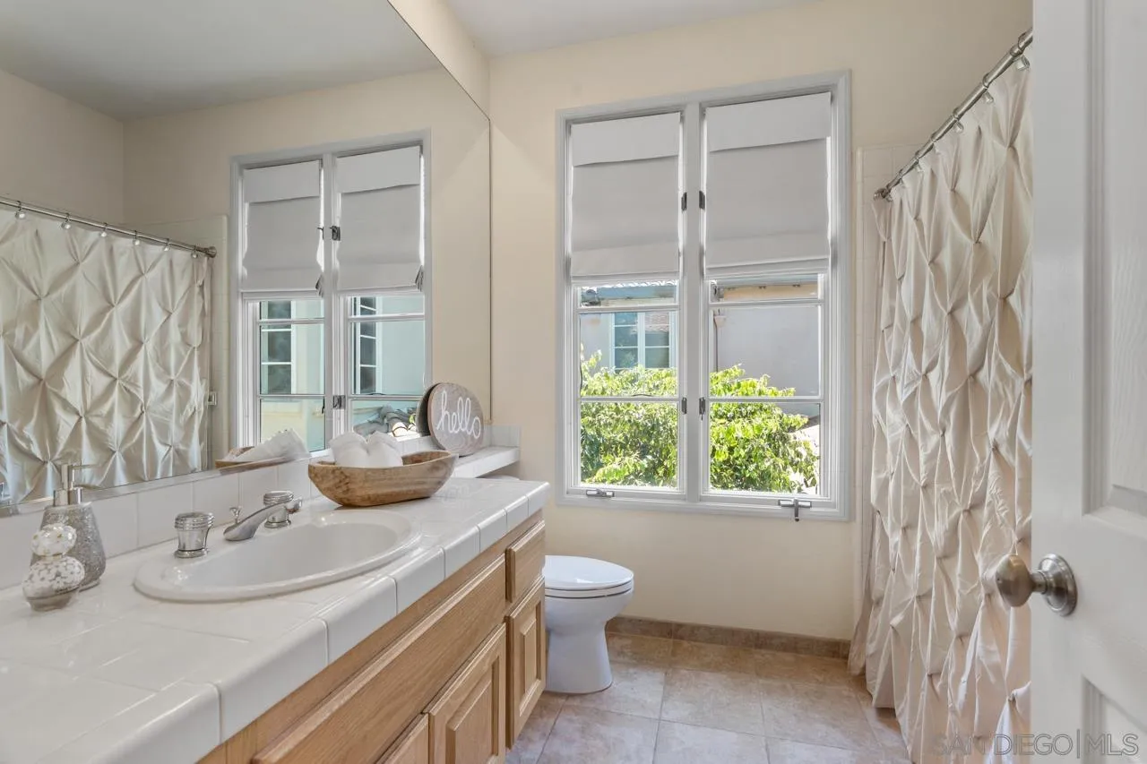 9678 Claiborne Square La Jolla, CA 92037 - Photo 32 of 38 a bathroom with a granite countertop sink toilet and shower