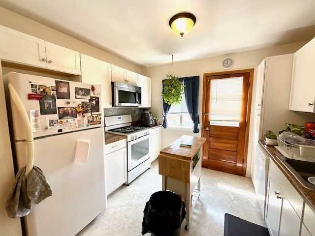 3 Hook Road, Unit 55G Poughkeepsie, NY 12601 - Photo 7 of 13 a kitchen with a refrigerator a stove a microwave a sink a dining table and chairs with wooden floor