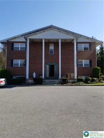 front view of a brick house with a yard
