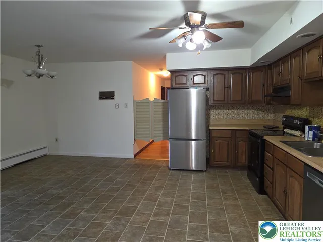 a kitchen with stainless steel appliances granite countertop a refrigerator a stove a sink dishwasher and a refrigerator with wooden floor