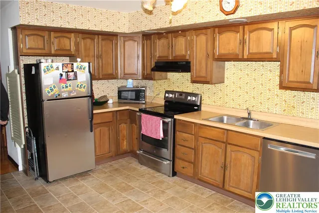 a kitchen with stainless steel appliances granite countertop a refrigerator sink and cabinets
