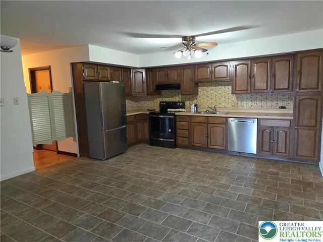 a kitchen with stainless steel appliances granite countertop a stove refrigerator and cabinets